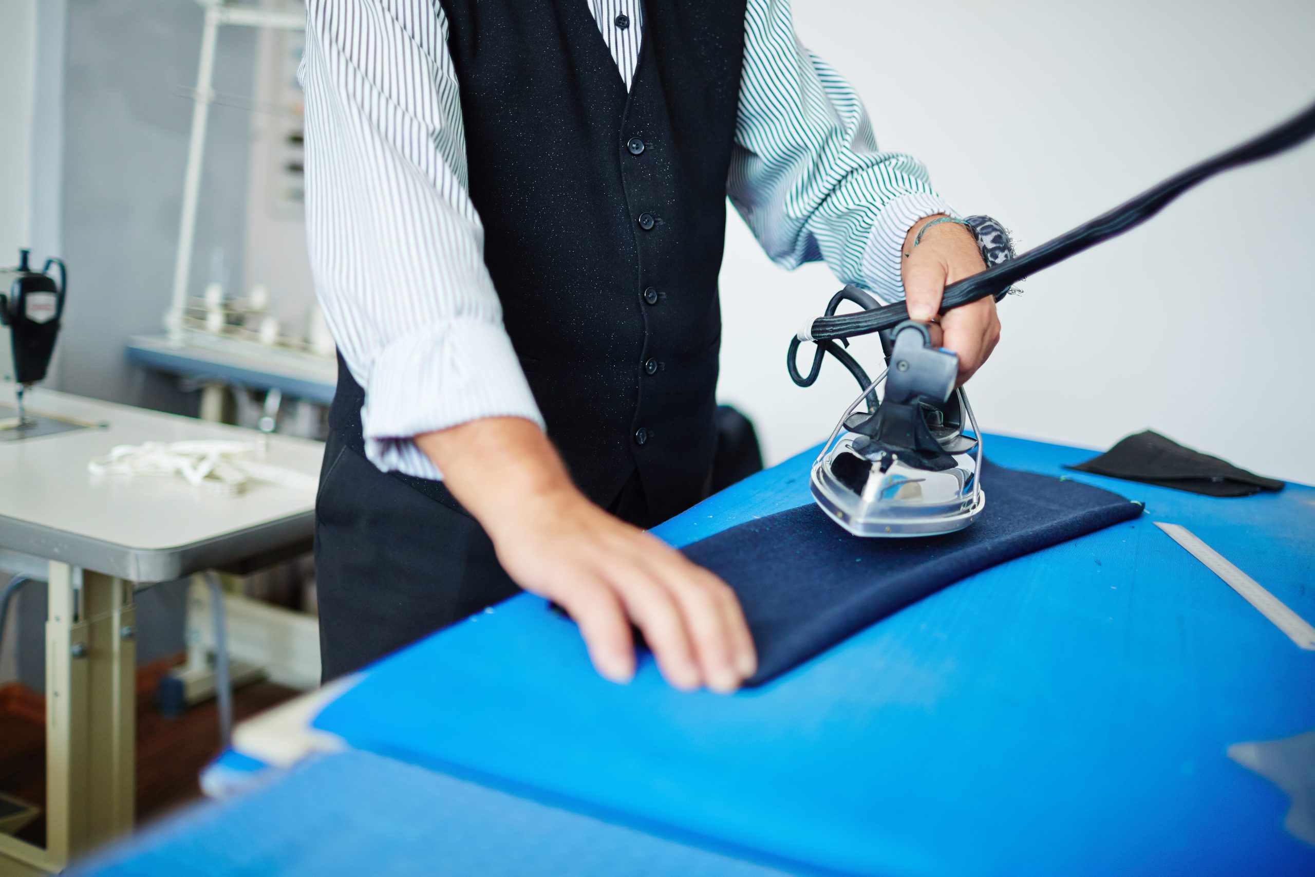 Manos realizando planchado cuidadoso de una prenda